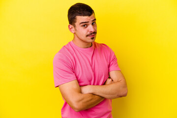 Young caucasian cool man isolated on yellow background unhappy looking in camera with sarcastic...