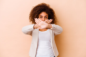Young african american woman isolated on beige background doing a denial gesture