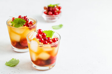 Red currants, strawberry summer refreshing cocktails, berry iced tea in glasses. Space fot text.