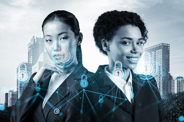 Two young attractive businesswoman in suits thinking about career opportunities at cybersecurity compliance division to protect clients confidential information. IT lock icons over Bangkok background.