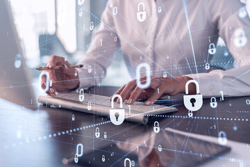 A woman programmer is typing a code on computer to protect a cyber security from hacker attacks and save clients confidential data. Padlock Hologram icons over the typing hands. Formal wear.