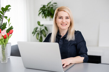 Cropped image of professional businesswoman working at her office via laptop, young female manager using portable computer device while sitting at modern loft, flare light, work process concept