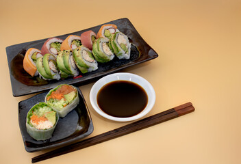 Close up of Japanese sushi roll avocado salmon carrots cucumber with soy sauce and chopsticks
