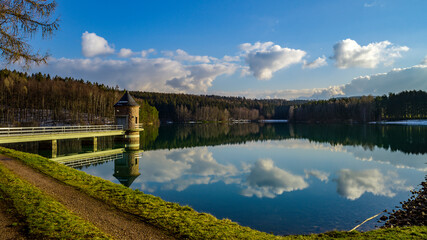 Fototapeta premium Landschaft mit Bäumen spiegelt sich in einem See - Talsperre Stollberg