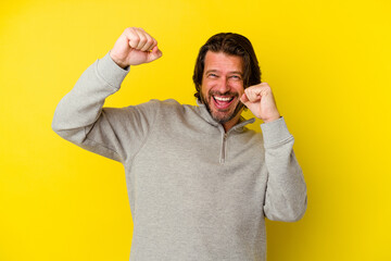 Middle age caucasian man isolated on yellow background dancing and having fun.