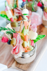 Spring appetizer with fruit, cheese and cured meats in a glass jar