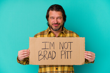 Middle age man holding a banner saying that he is not a famous person