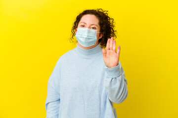 Young woman with Down syndrome wearing an antivirus mask isolated smiling cheerful showing number five with fingers.