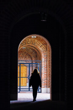 Stockholm, Sweden A Woman Walks Under An Archway In An Outdoor Corridor At The Stockholm Stadion Olympic Stadium.