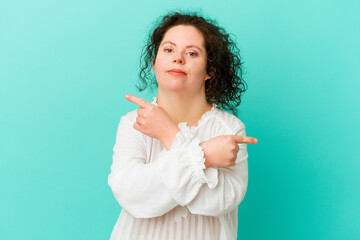 Woman with Down syndrome isolated points sideways, is trying to choose between two options.