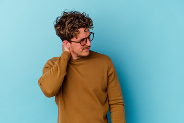 Young caucasian man wearing eyeglasses isolated on blue background having a neck pain due to stress, massaging and touching it with hand.