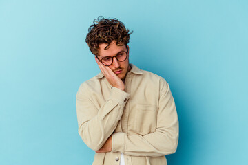 Fototapeta na wymiar Young caucasian man wearing eyeglasses isolated on blue background who is bored, fatigued and need a relax day.