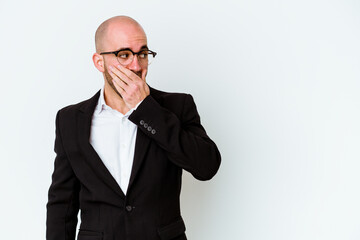 Young business caucasian bald man isolated on blue background thoughtful looking to a copy space covering mouth with hand.