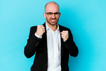 Young business caucasian bald man isolated on blue background upset screaming with tense hands.