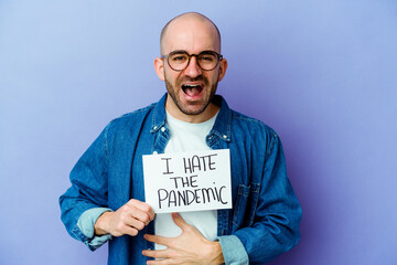 Young caucasian bald man holding a I hate the pandemic placard isolated on blue background laughing...