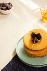 Pancakes on turquoise plate with honey and blackberries. Breakfast. Meal.