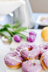 Homemade Purple donuts on dessert stand with Spring flowers