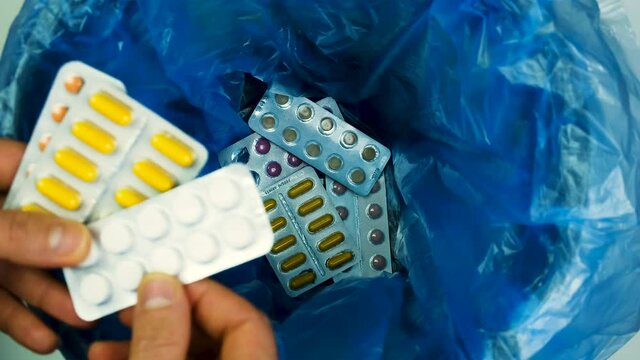 throw the pills into the trash can. selective focus.