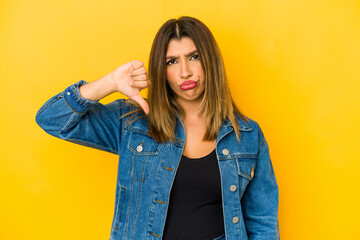 Young indian woman isolated on yellow background showing thumb down, disappointment concept.