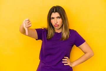 Young indian woman isolated on yellow background showing thumb down, disappointment concept.