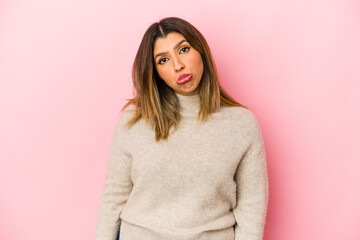 Young indian woman isolated on pink background sad, serious face, feeling miserable and displeased.