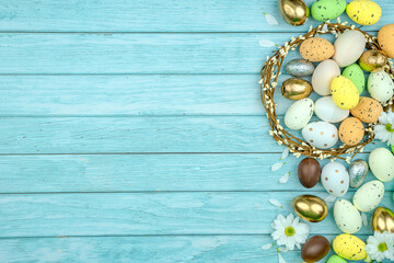 decorative eggs, chamomile flowers, wreath on light blue wooden boards