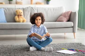 Black girl sitting on the floor, reading book