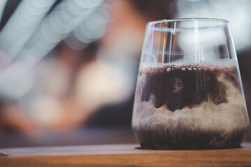 Glass of Iced cocoa cool drink served on wood tray.