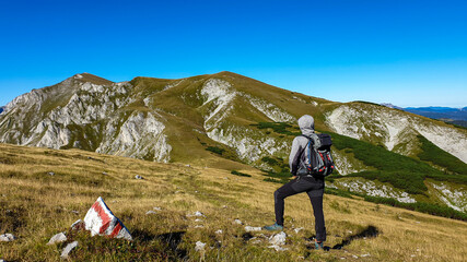 A man with a hiking backpack enjoying the view on the high peaks, while hiking to Hohe Weichsel in...