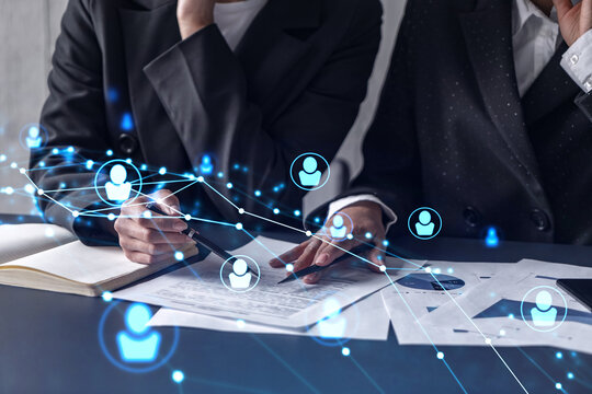 Two HR specialists analyzing the market of freshers to boost the intern program at international consulting company. Hiring new talented crew. Social media hologram icons. Women in business. - Powered by Adobe