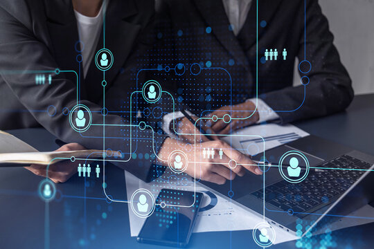 Two HR specialists analyzing the market of freshers to boost the intern program at international consulting company. Hiring new talented crew. Social media hologram icons. Women in business.