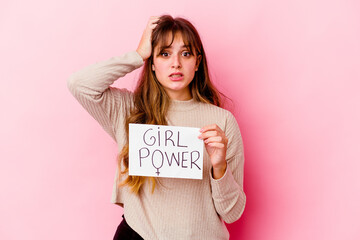 Fototapeta na wymiar Young caucasian woman holding a girl power placard isolated on pink background being shocked, she has remembered important meeting.