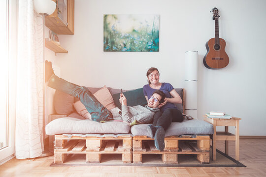 Simple lifestyle: Couple is sitting on cozy palette sofa, living room