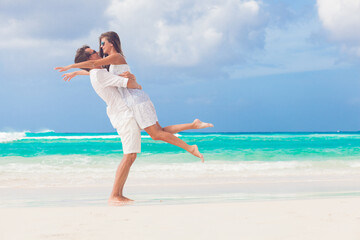 happy young couple having fun by the beach