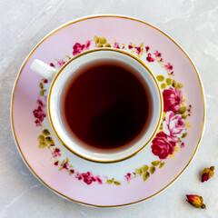Top view of a cup of tea with dried roses
