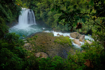Ecuador waterfall, river with white stream, rainy day, green vegetation in national park Sumaco. Green tropical forest, with waterfall in South America. Tropic nature landscape with river.