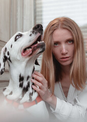 A young ginger woman with her Dalmation dog in the street.