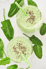Detox green smoothie with spinach, chia seeds and kiwi on a light gray slate, stone or concrete background. Top view with copy space.