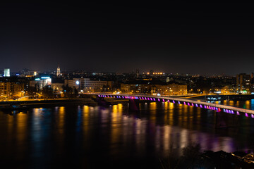Fototapeta na wymiar Night panoramic view of Novi Sad, Serbia cityscape with bridges, Danube river and Petrovaradin fortress with beautiful colorful street lights from the town