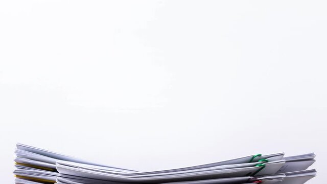 4K Stop motion of close-up stack overload document report paper with paperclip place decrease on white background, business and education concept footage paperless used.