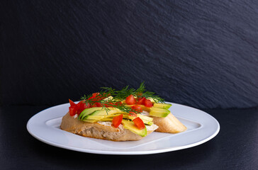 canapes of avocado wedges and a slice of tomato with dill
