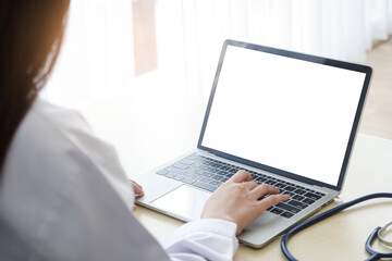 A woman doctor at work typed information on a white screen laptop. Concept of online technology...