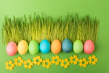 Easter composition of fresh cut grass laid in the face of kerb, multi-colored eggs