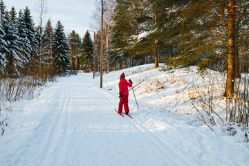 Fototapeta na wymiar Small child in the ski track at winter forest in Finland.