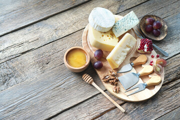Cheese board with camembert cheese, parmesan cheese, maasdam cheese. Top view, copy space.