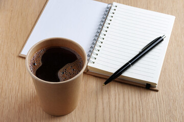 Obraz na płótnie Canvas Glass of coffee, notepad and pen