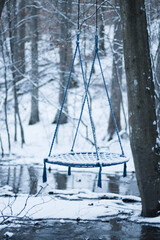 snow-covered swing in the forest