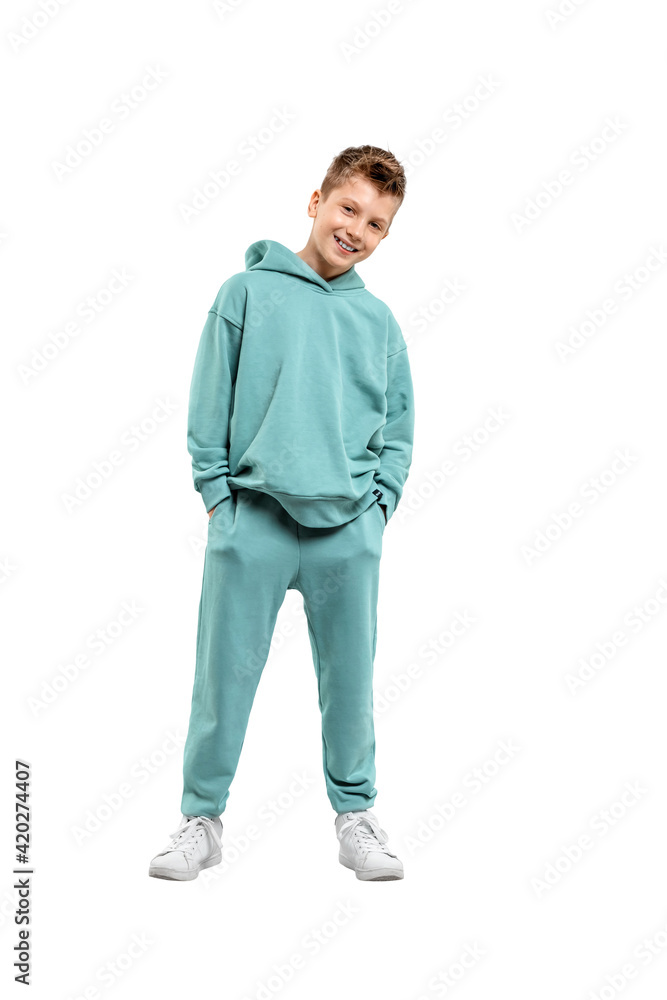 Wall mural boy in a turquoise suit and white sneakers isolated on a white background.