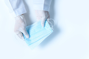 Fototapeta premium Doctor hands in medical gloves holding surgical protective mask isolated