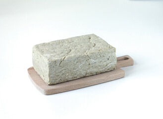 One piece of sunflower halva on a light background. Space for text